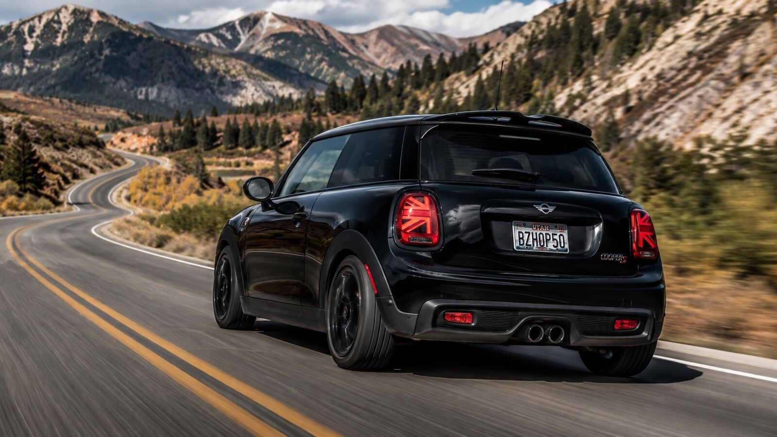 Black MINI Cooper S driving on a winding mountain road